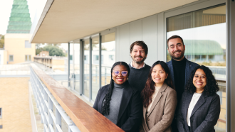 The 2023/24 Skoll Scholar cohort standing on the SBS balcony smiling. 