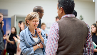 Marya Besharov speaking with a student at a seminar.